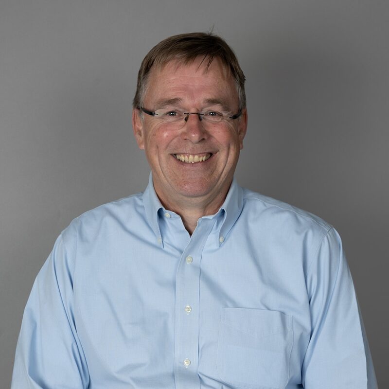 Smiling middle-aged man with glasses in blue shirt