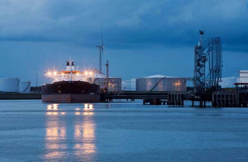 Large oil tanker docked at industrial port at dusk