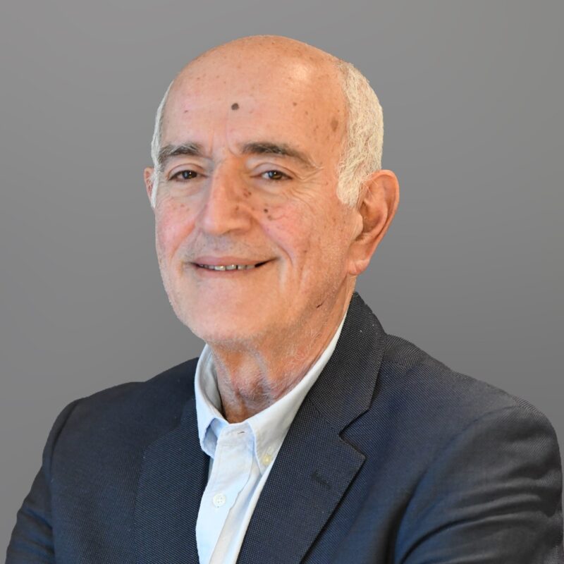 Smiling elderly man in dark blazer and light blue shirt