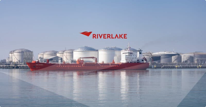 Riverlake red tanker ship docked near industrial storage tanks